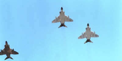 F-4 Phantom II aircraft from the Hawaii Air National Guard fly in a missing man formation to honor the Unknown Serviceman of the Vietnam Era. The serviceman's casket is being placed