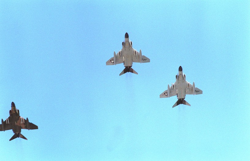 F-4 Phantom II aircraft from the Hawaii Air National Guard fly in a missing man formation to honor the Unknown Serviceman of the Vietnam Era. The serviceman's casket is being placed