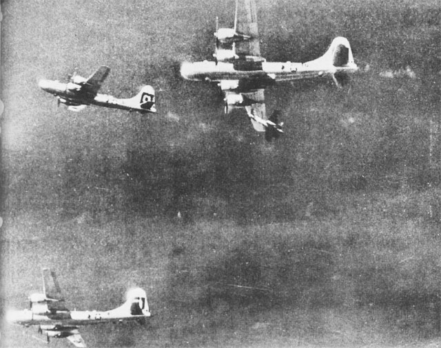 Fighter aircraft making a pass under a B-29 (July 7, 1944)