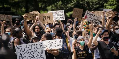 crowd of protesters holding signs