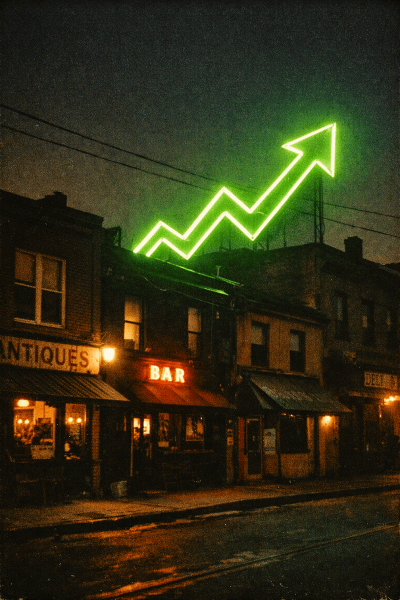 Green neon arrow pointing upward above buildings with shops and a bar at night.