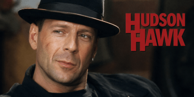 AI-generated cinematic portrait of Bruce Willis as Hudson Hawk, wearing a black fedora and dark clothing beside the red words “Hudson Hawk.”