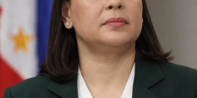 AI-generated editorial-style portrait of Philippine Vice President Sara Duterte wearing a dark blazer and white blouse, with a blurred Philippine flag-style background.